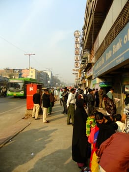 People waiting for bus on the street of Delhi, India