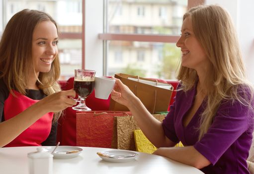 two girls drinking coffee in a cafeteria