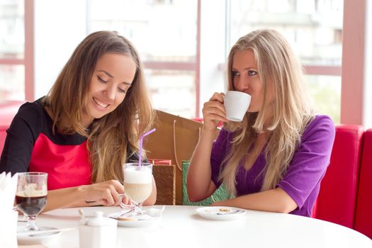 two girls drinking coffee in a cafeteria