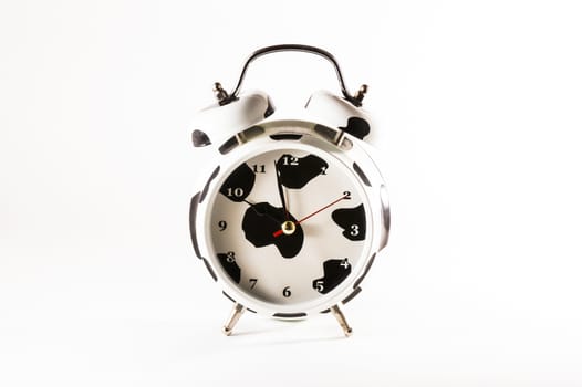 White alarm clock with black stains on white background