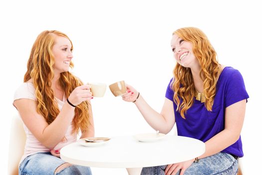 two happy redhead women clink glasses with coffee cups on white background