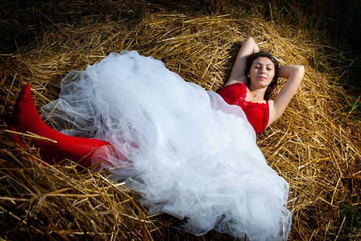 Woman in white skirt laying in hay