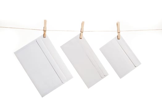 Three envelope held by clothespins on a string