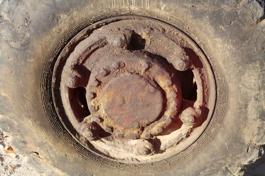 Old tractor tire with rusty wheel with corrosion