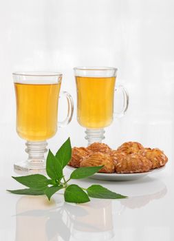 Tea in glass cups, tasty cookies and fresh mint leaves.