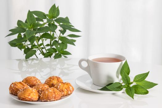 Tea in glass cups, fresh mint and tasty cookies.