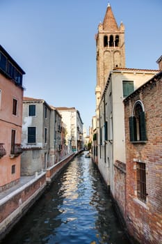 Canal in Venezia with a tower in the background