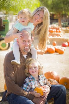 Attractive Family Portrait in a Rustic Ranch Setting at the Pumpkin Patch.
