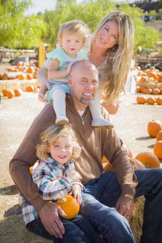 Attractive Family Portrait in a Rustic Ranch Setting at the Pumpkin Patch.
