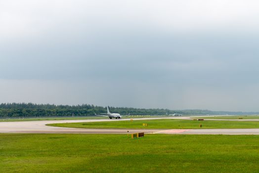 Plane speed up on airport runway in modern airport under cloudy sky