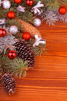 Frame of Spruce Branch and Fir Cones with Hoarfrost, Red and Silver Baubles, Bows closeup on Wooden background