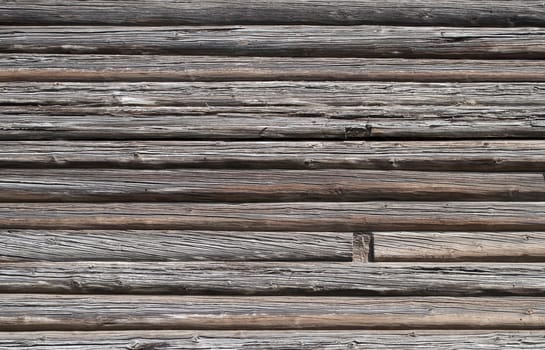 Fragment of old weathered log wall, useful as background