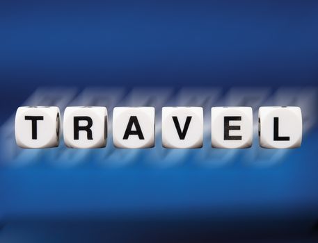 travel spelled in dice letters reflected on blue background in motion blur 