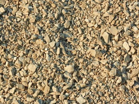 Crushed stone in bright sunlight as a texture