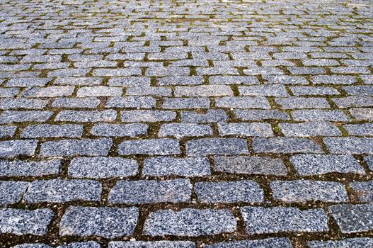 Fragment of grey granite paving stones in the square