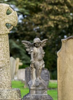 Statue of angel above grave of dead girl in old cemetery in Shropshire in England