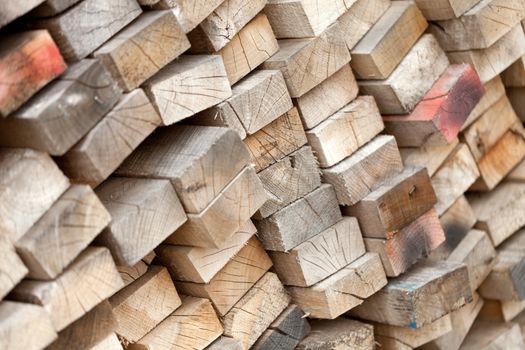 Old lumber and two by fours stacked in a wood pile. Shallow depth of field.