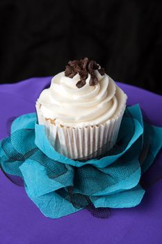 Close up of a decadent gourmet cupcake with chocolate and vanilla frosting. 