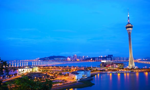 Urban landscape of Macau with famous traveling tower under blue sky near river in Macao, Asia. 
