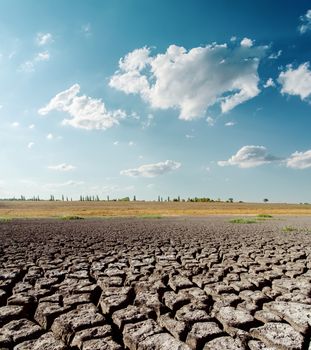 dry desert under blue sky with clouds