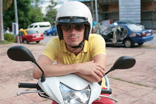 Young man on a scooter wearing sunglasses