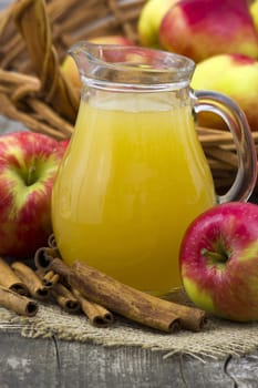 Apple juice and apples on wooden background