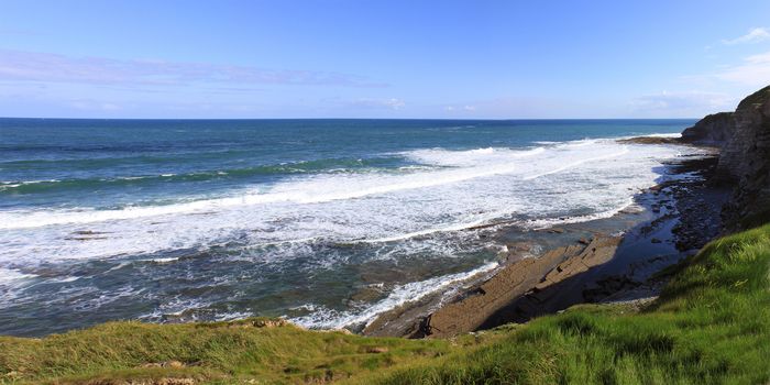 panorama of a horizon on the sea with its rugged coastline on a blue sky