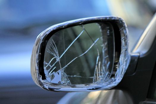 Close up of damaged rearview mirror repaired with scotch on a car