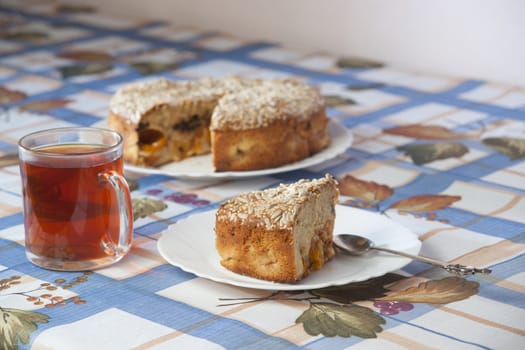 Apricot pie on plate and cup with tea. High resolution