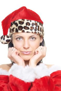 Serene lady in the red Santa Claus costume and hat on a white background. Hands on the chin