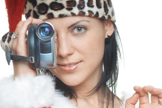 Woman in Santa Claus costume using video camera on a white background