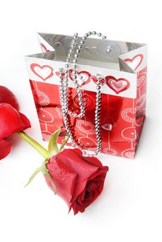 Red rose and package with hearts as a gift for Valentine day