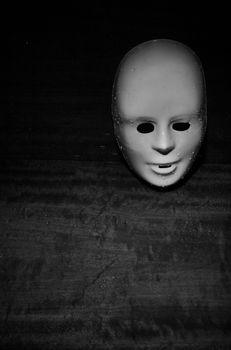 Wet plastic mask on a dark wooden background