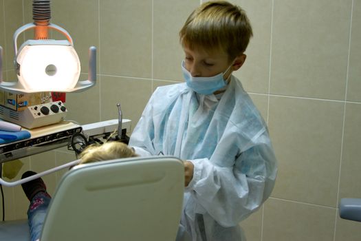 A couple of kids playing doctor at the dentist