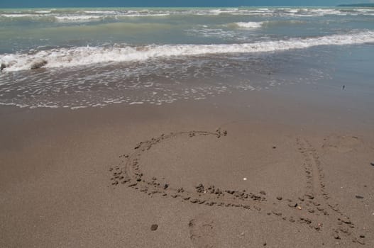 Love heart on the beach washed off a wave