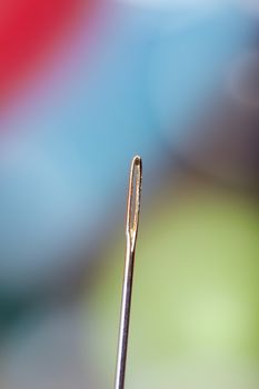 Sewing needle on a colorful background. Extremely close-up photo