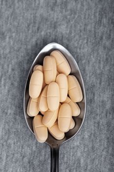 Medical pills on a metal spoon. Close-up photo