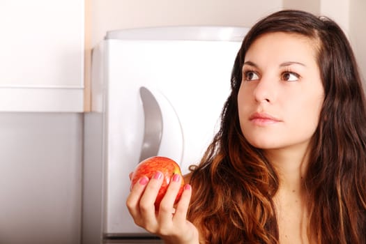 A young adult woman holding a Apple.