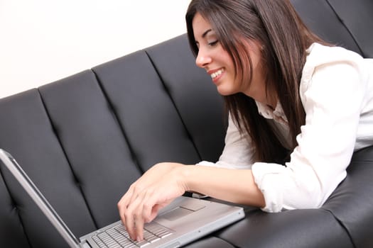 A young woman surfing on the Internet with a Laptop.  
