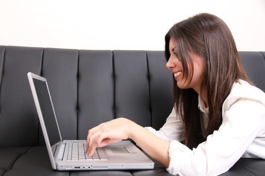 A young woman surfing on the Internet with a Laptop.  
