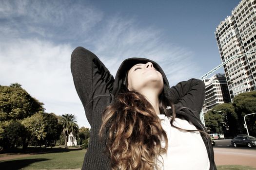 A young woman enjoying the sunlight in the Park.			
