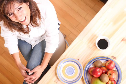 Portrait of a beautiful mature woman sitting in the kitchen. 