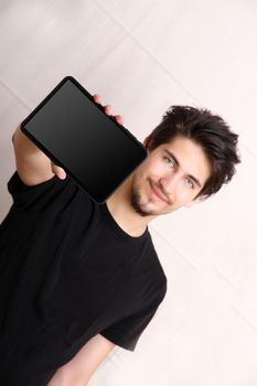 A young hispanic man holding a Tablet PC.