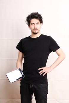 A young hispanic man holding a Tablet PC.