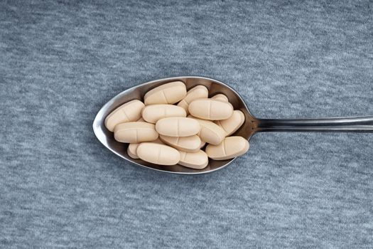 Pills on a metal spoon. Close-up photo
