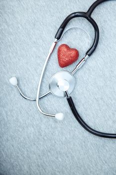 Medical stethoscope and heart on a blue textured background