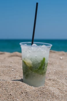 Shot of Mojito cocktail on the beach