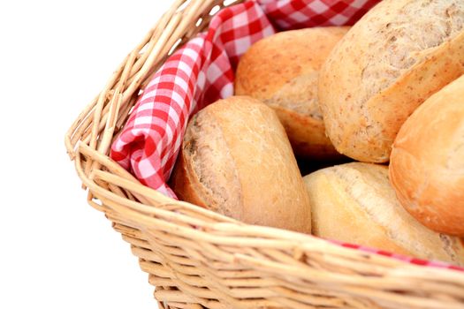 Closeup of fresh bread rolls in a wicker basket, isolated on a white background