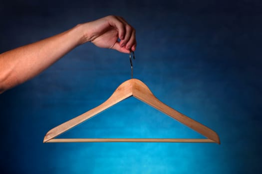 Clothes Hanger in a hand on the dark background