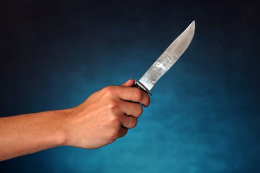 Hand with a Knife on the dark background